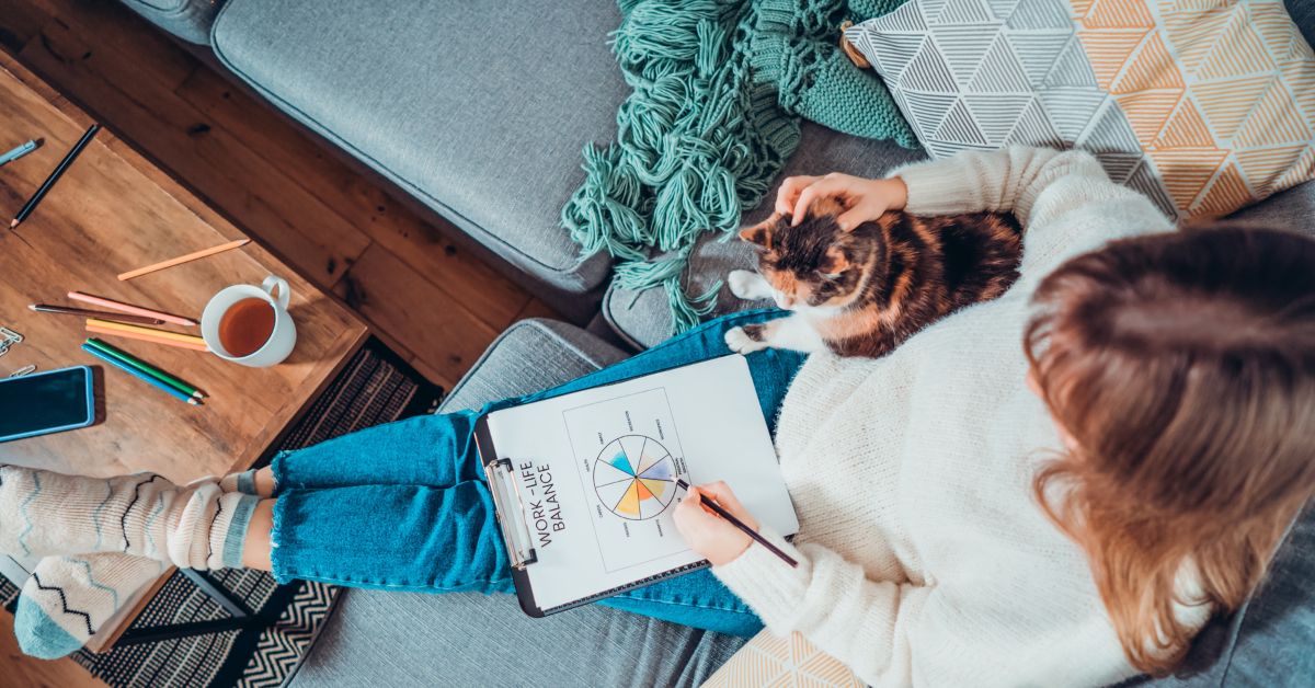 Top View Relaxed Young Woman Drawing Work-Life Balance Wheel Sitting on the Sofa with Cat Pet at Home. Self-Reflection and Life Planning. Coaching Tools. Finding Balance in Your Life. Selective Focus.