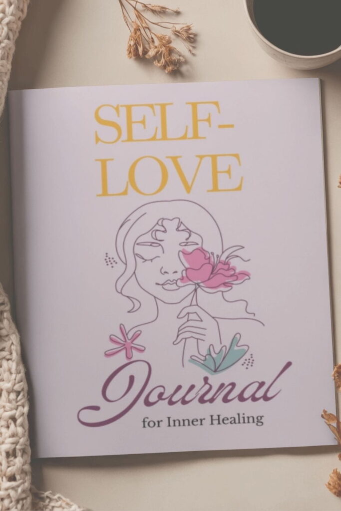 A guided self-love journal on a clean surface, a blanket and a mug with coffee. Self-love journaling practice for grounding.